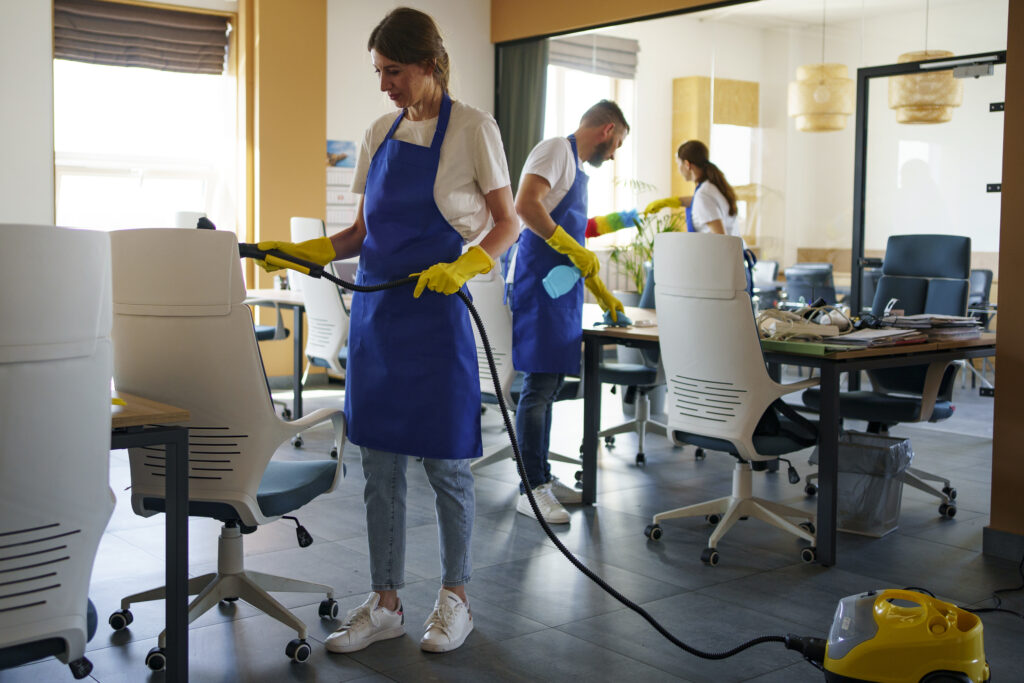 professional cleaning service person using vacuum cleaner office
